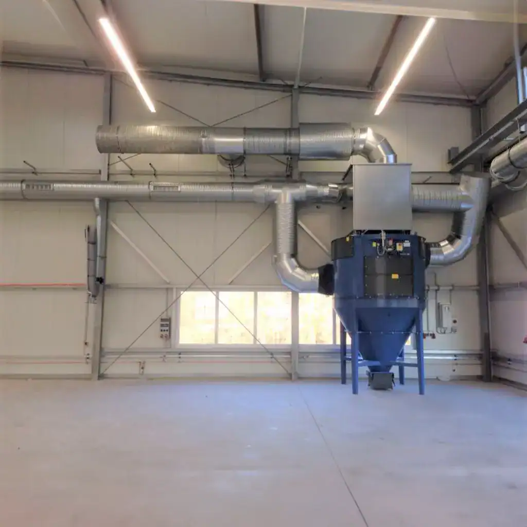 Staubabsauganlage in Industriehalle, VAUPEL Absaugtechnik, leistungsstarke industrielle Staubreinigung, effiziente Staubabsaugungssysteme für Fabriken und Produktionsanlagen.