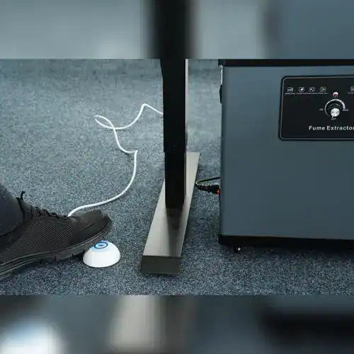 Absaugtechnik von VAUPEL bei der Arbeit zur Rauchabsaugung unter einem Schreibtisch, um Arbeitsplatz- und Gesundheitsschutz zu gewährleisten.